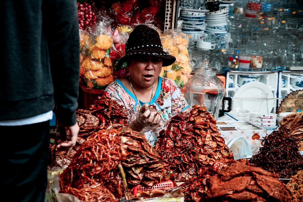 woman in blue and white long sleeve shirt standing in front of red and white shrimp