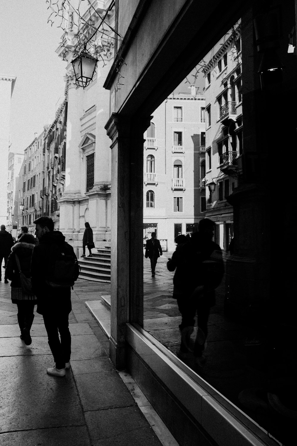 Foto en escala de grises de personas caminando por la acera