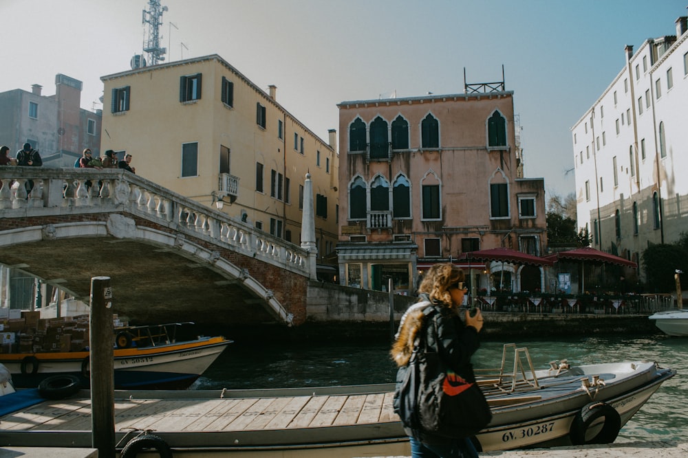 woman in black jacket standing on bridge during daytime