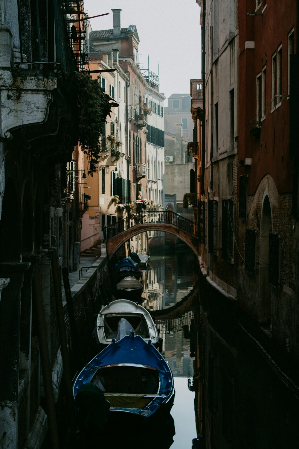 blue boat on river between buildings during daytime