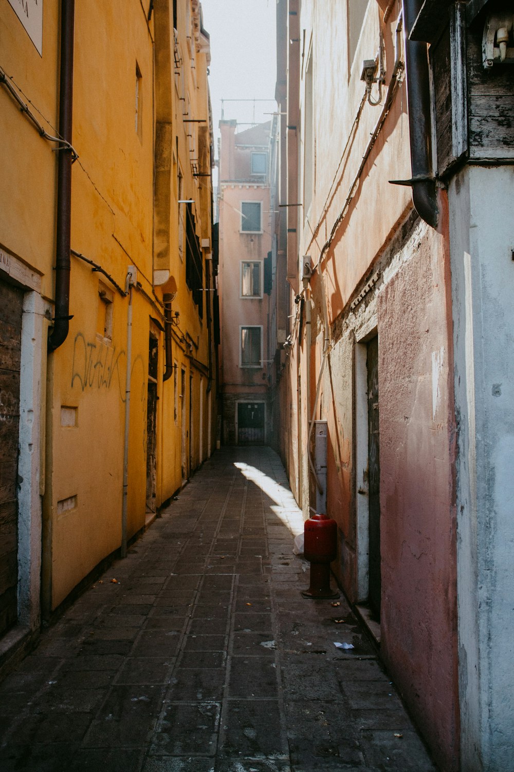 empty hallway between concrete buildings during daytime