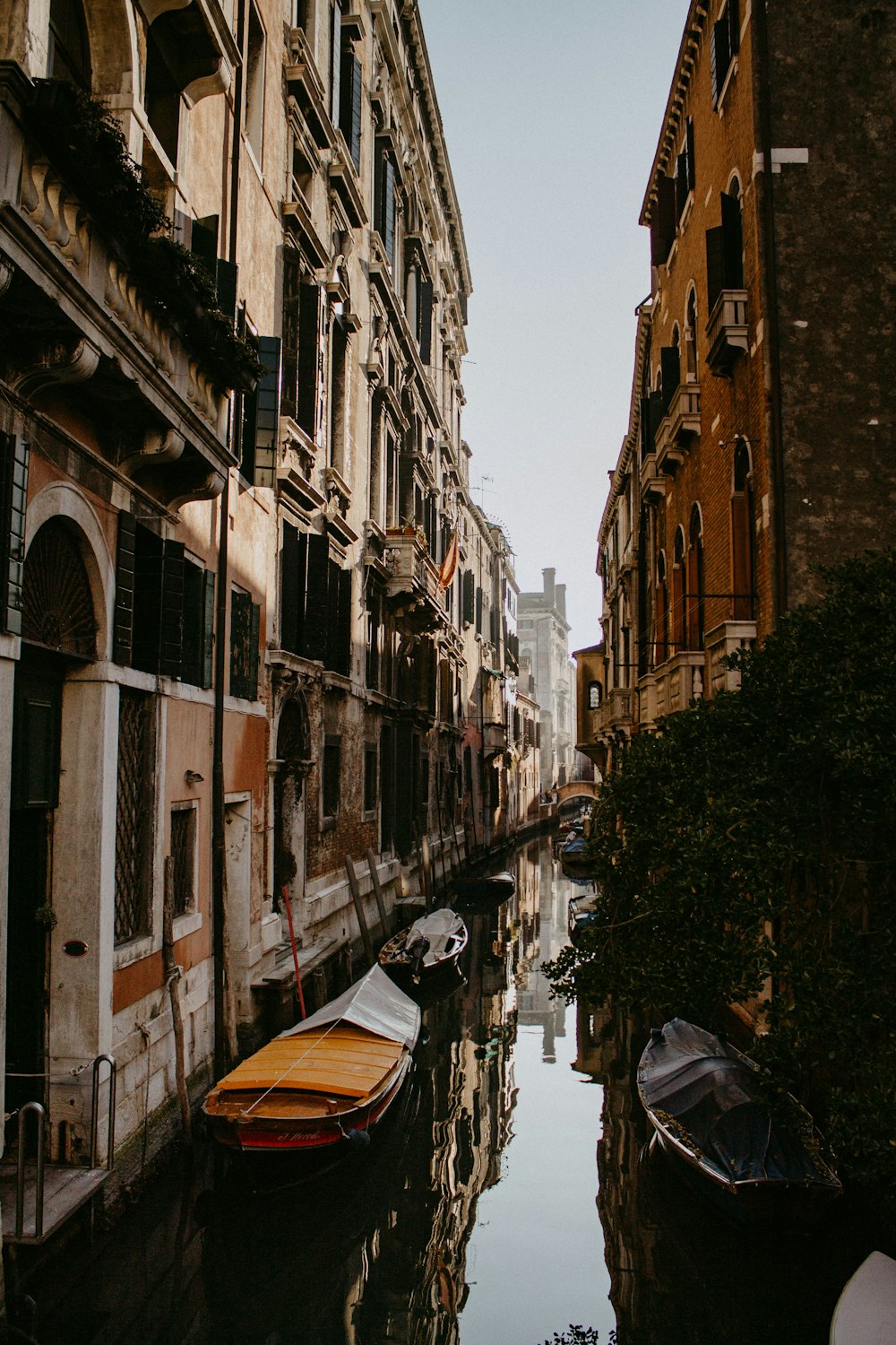 brown boat on river between buildings during daytime