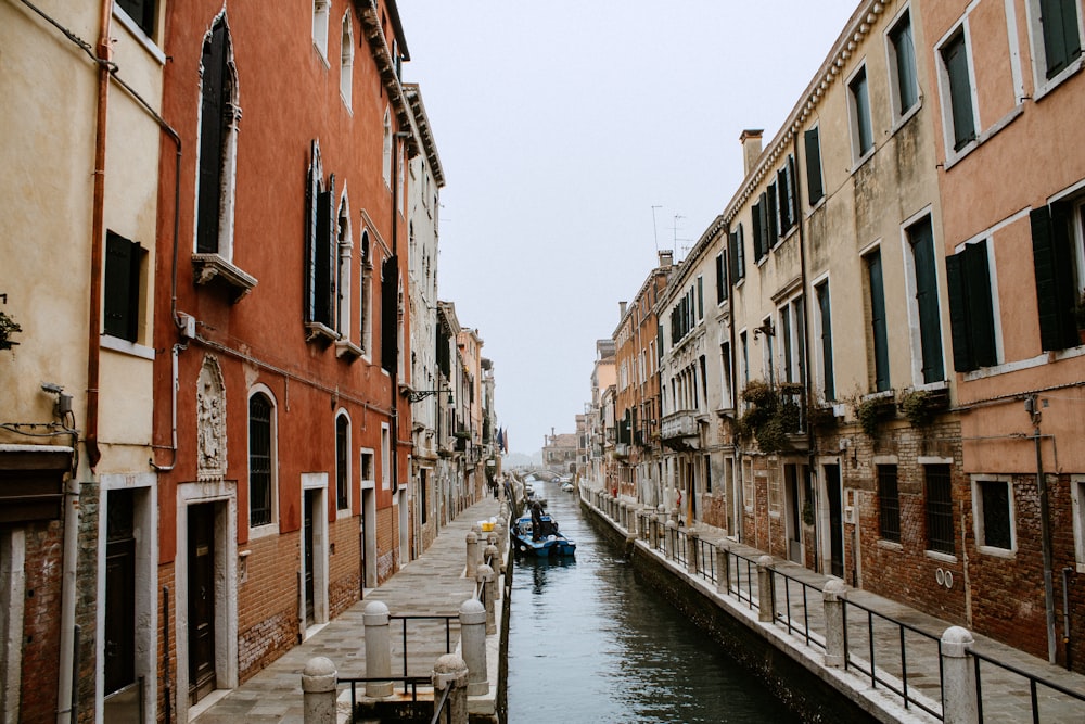 boat on river between buildings during daytime