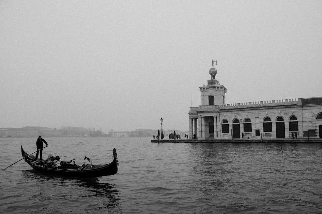 grayscale photo of man riding on boat on sea