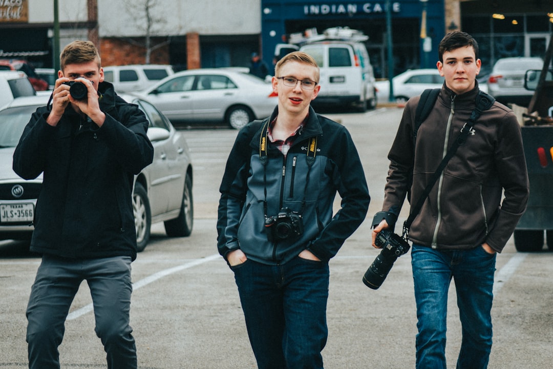 man in black jacket holding black dslr camera