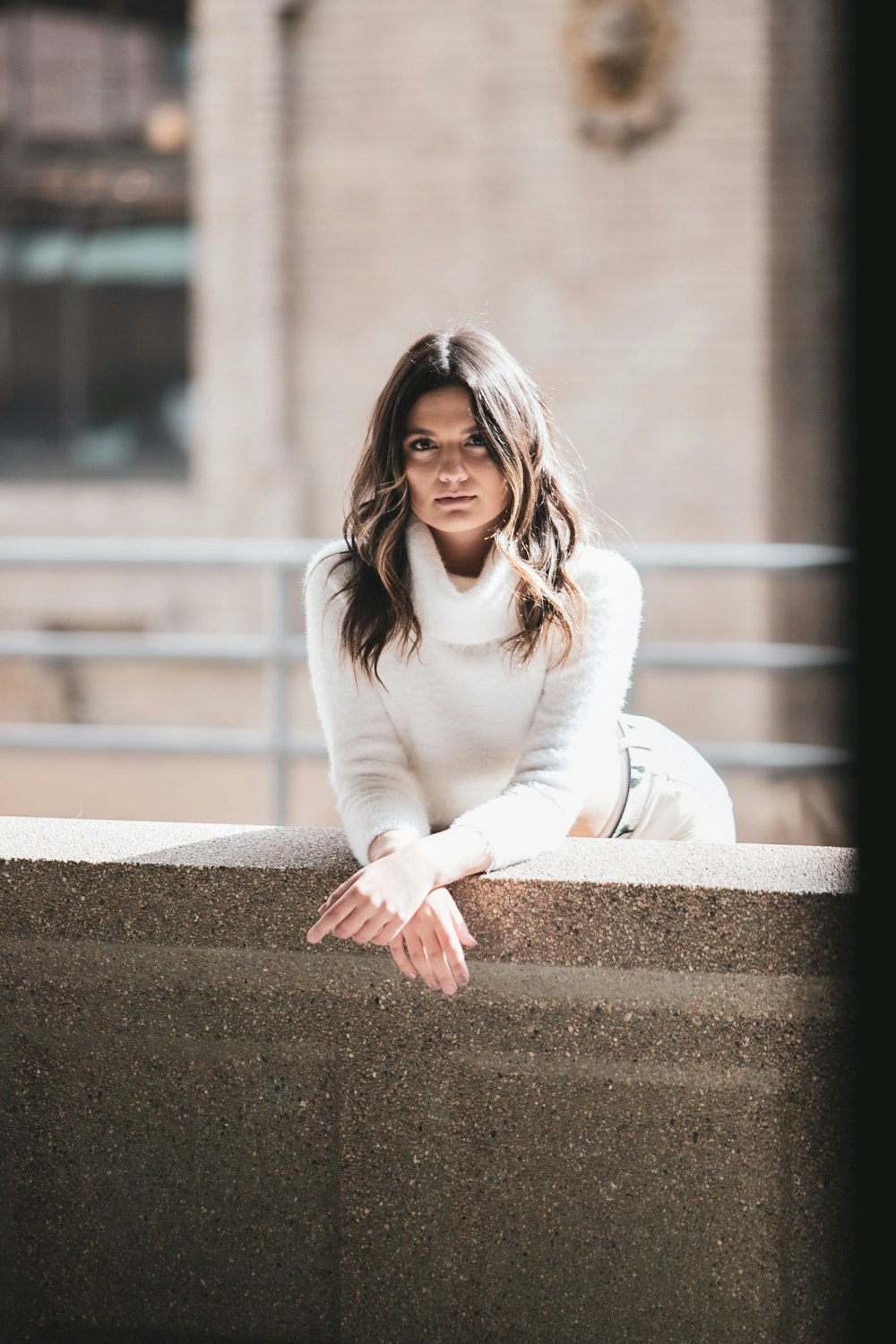 woman in white long sleeve shirt sitting on concrete bench