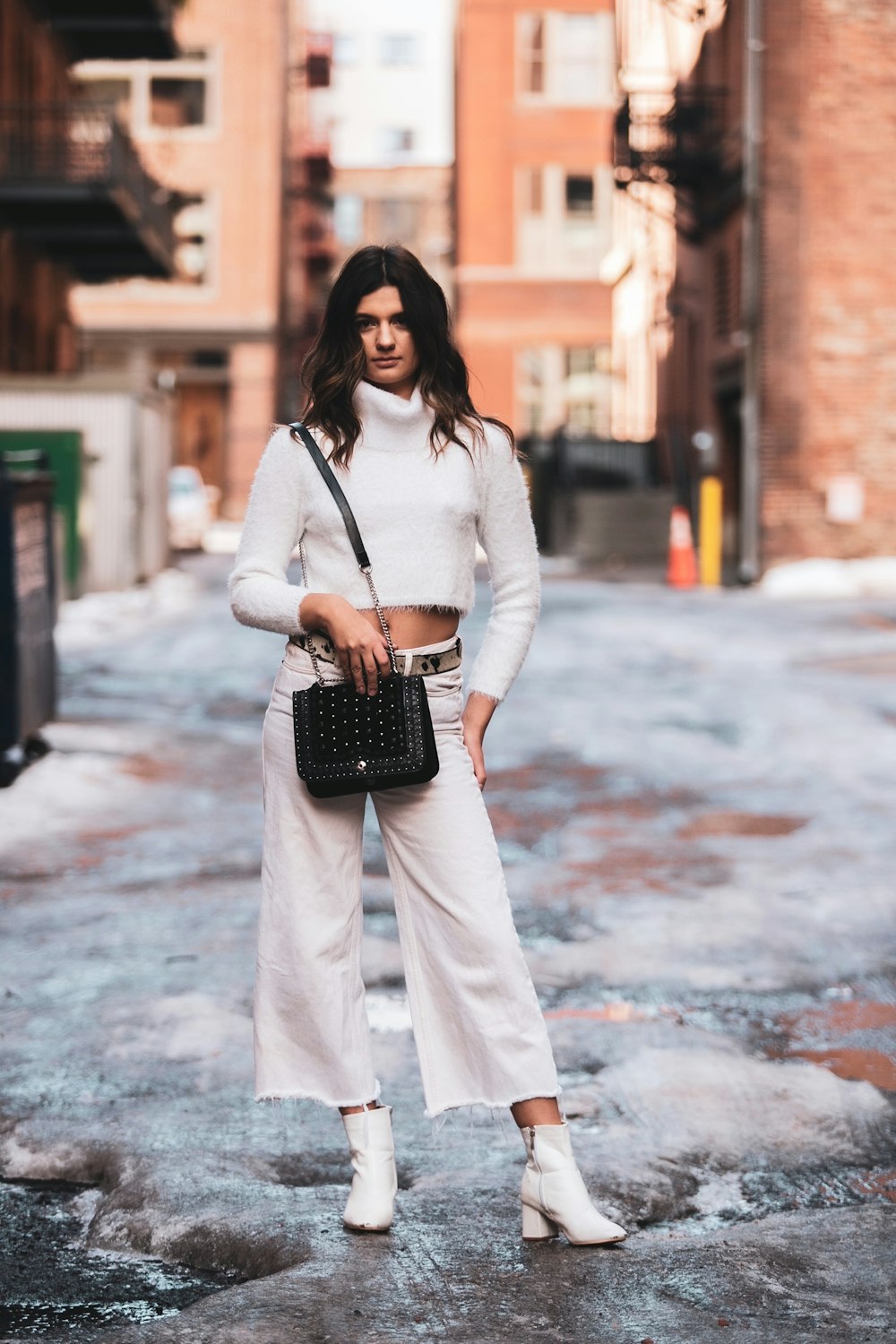 woman in white long sleeve dress holding black and white polka dot handbag