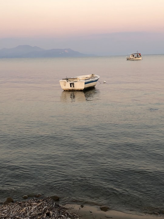 white and brown boat on sea during daytime in Kavos Greece