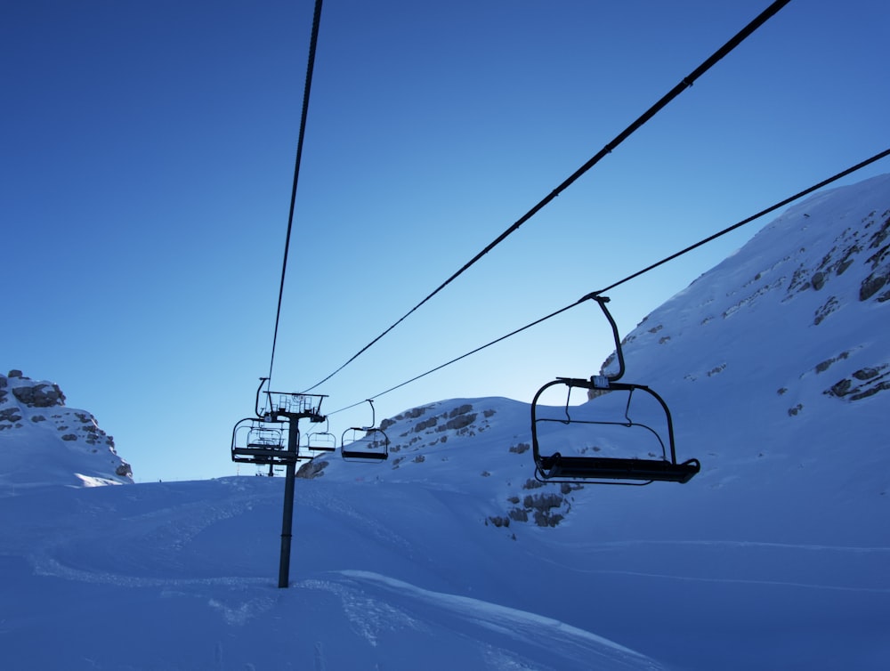 cable cars over snow covered mountain during daytime