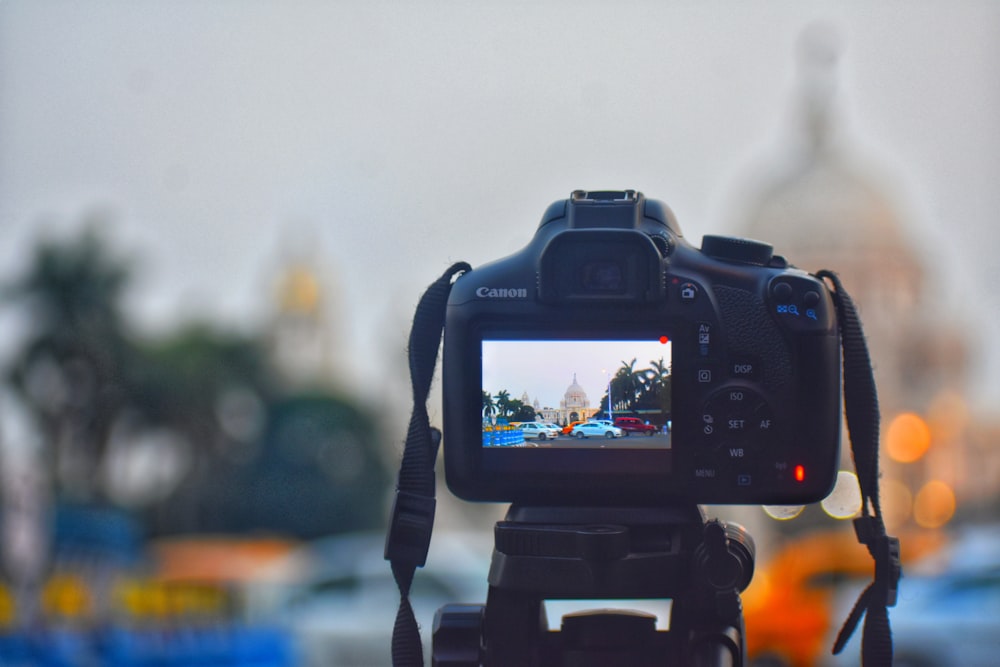 black dslr camera taking photo of city during daytime