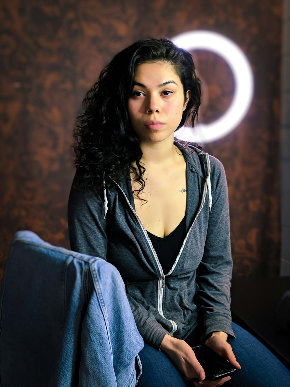 woman in black v neck long sleeve shirt and blue denim jeans sitting on black chair