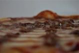Close-up of a deep-pan pizza bubbling with melted cheese and fresh toppings.