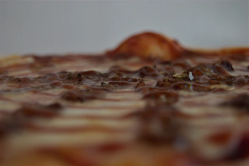 A close-up of a sizzling, cheesy pizza fresh out of the oven with vibrant toppings.