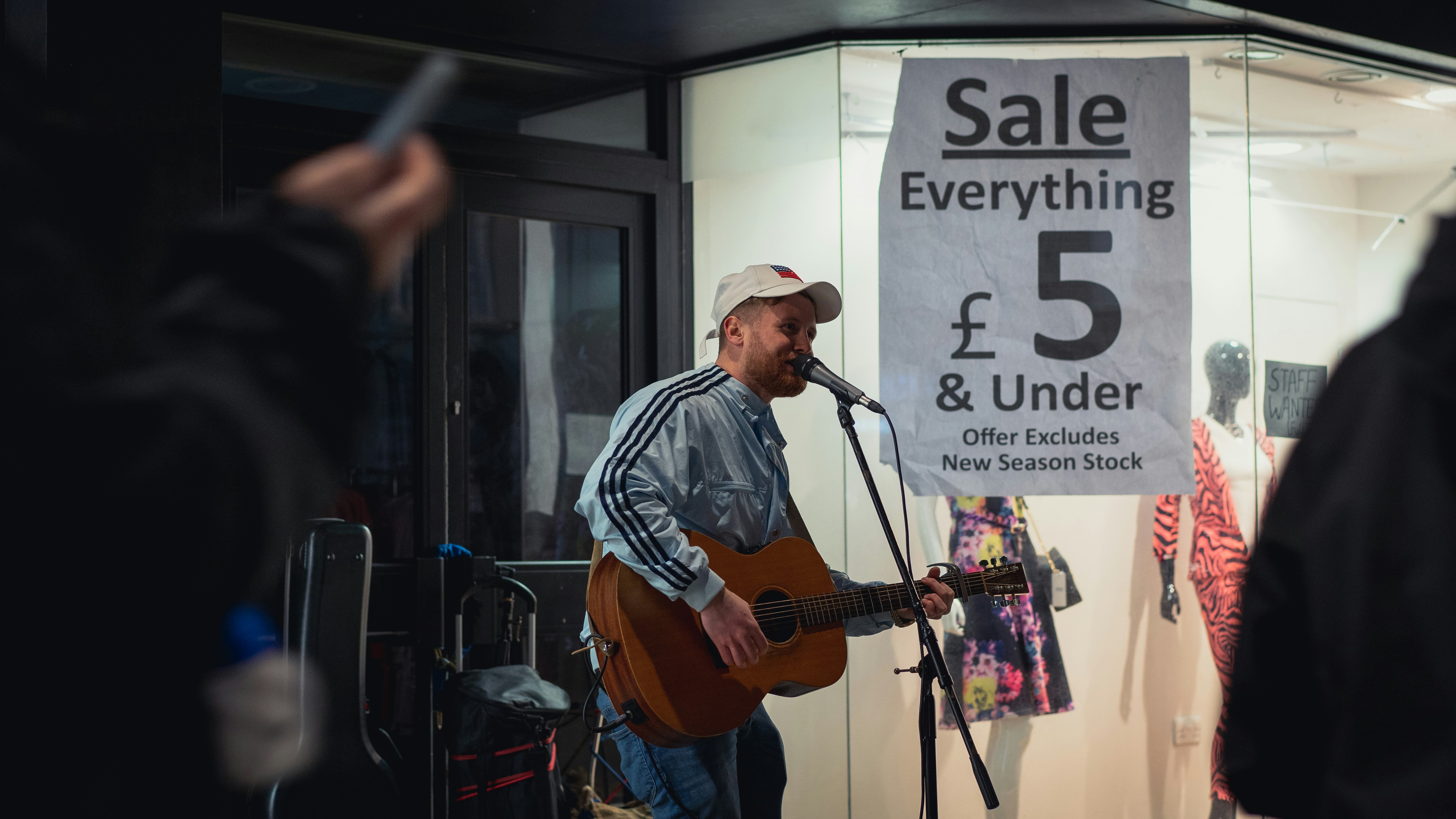 man in blue and white plaid dress shirt playing brown acoustic guitar
