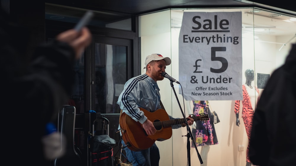 man in blue and white plaid dress shirt playing brown acoustic guitar