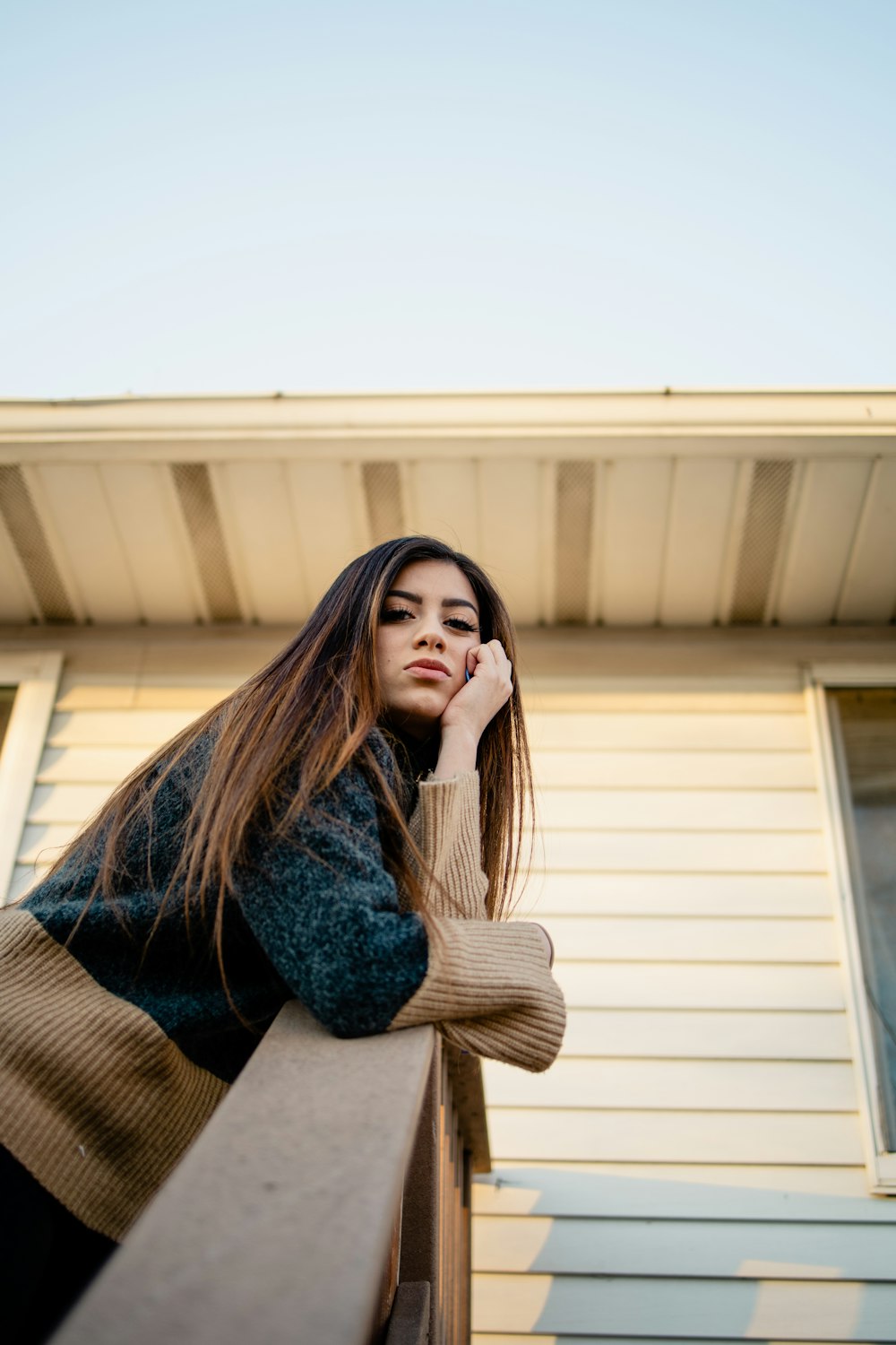 woman in blue denim jacket sitting on brown chair