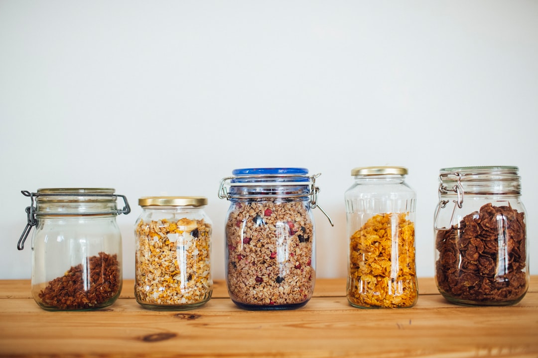 two clear glass jars with brown and black beads