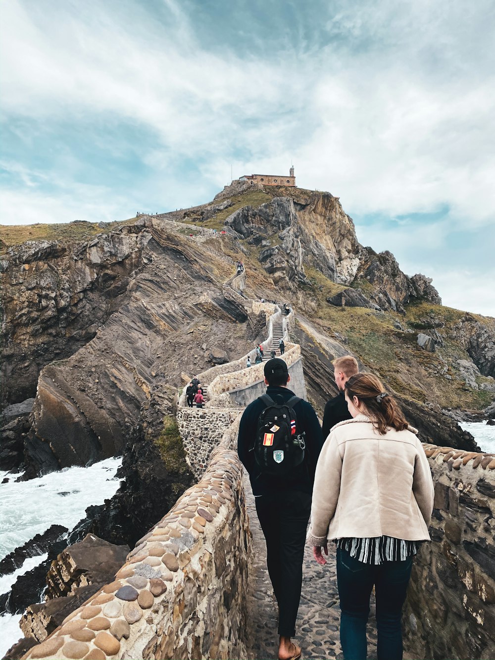 man in black jacket standing on rocky mountain during daytime