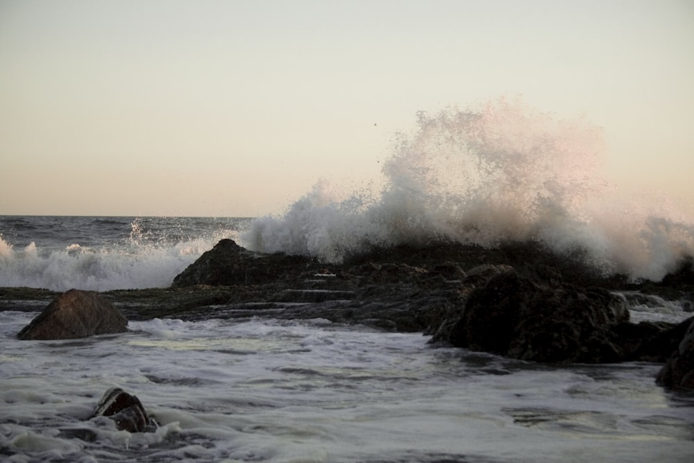 ocean waves crashing on rocks during daytime