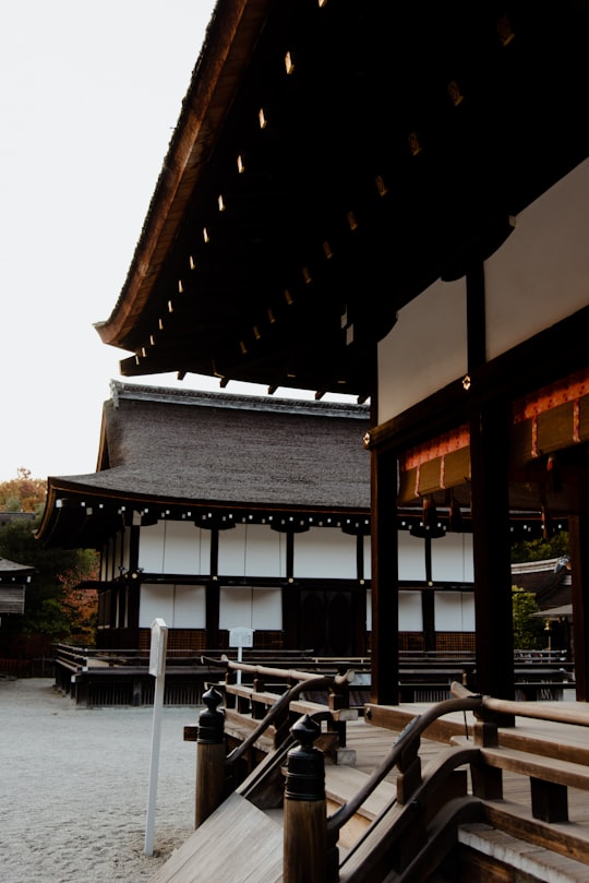 brown wooden bench near brown wooden house during daytime in Shimogamo-Jinja Japan