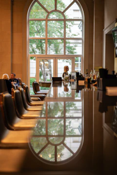 a long table with chairs in front of a large window