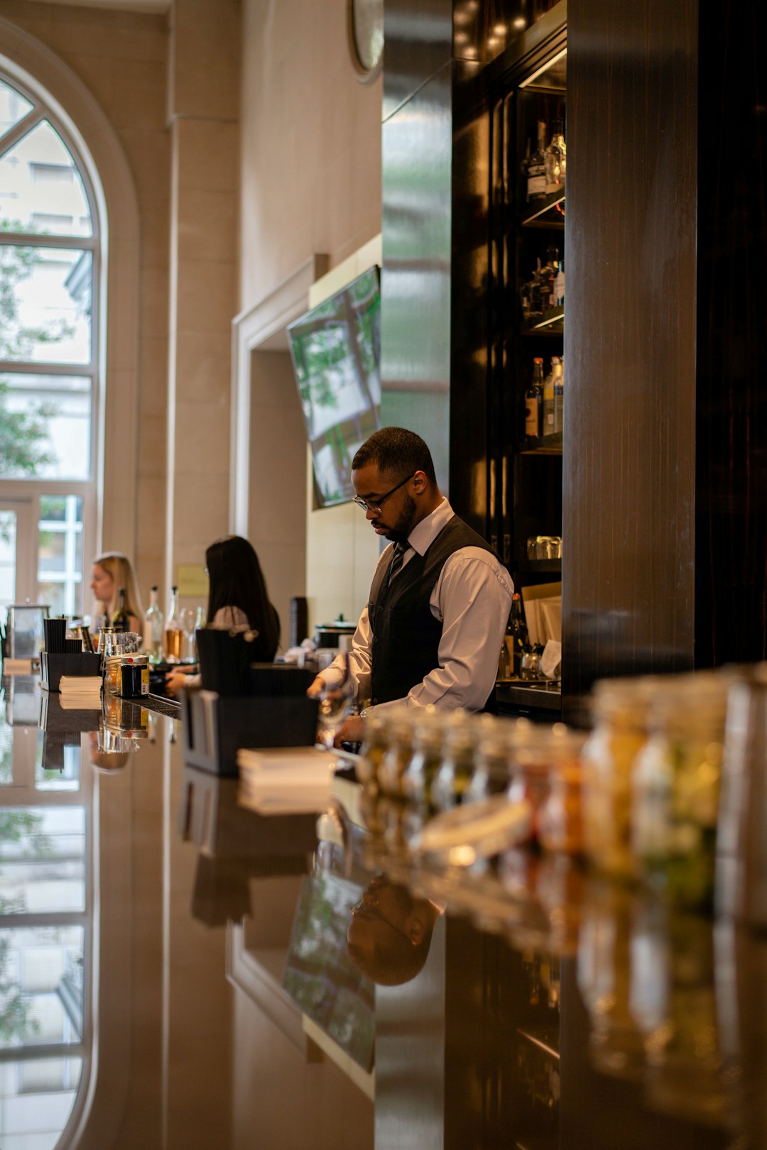 man in black jacket standing in front of counter