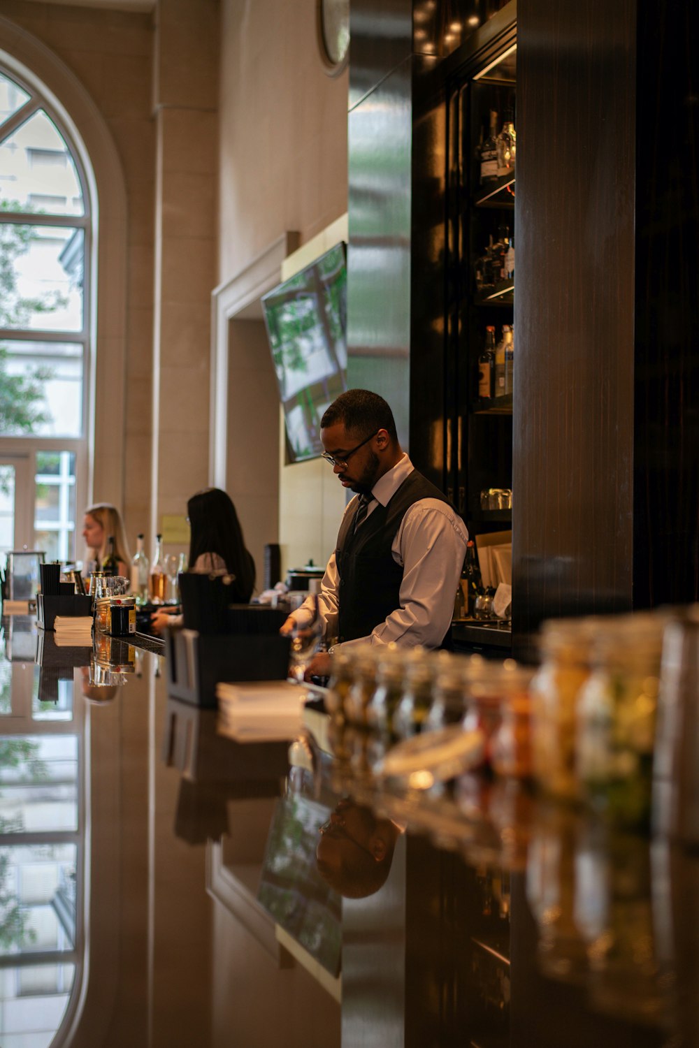 man in black jacket standing in front of counter