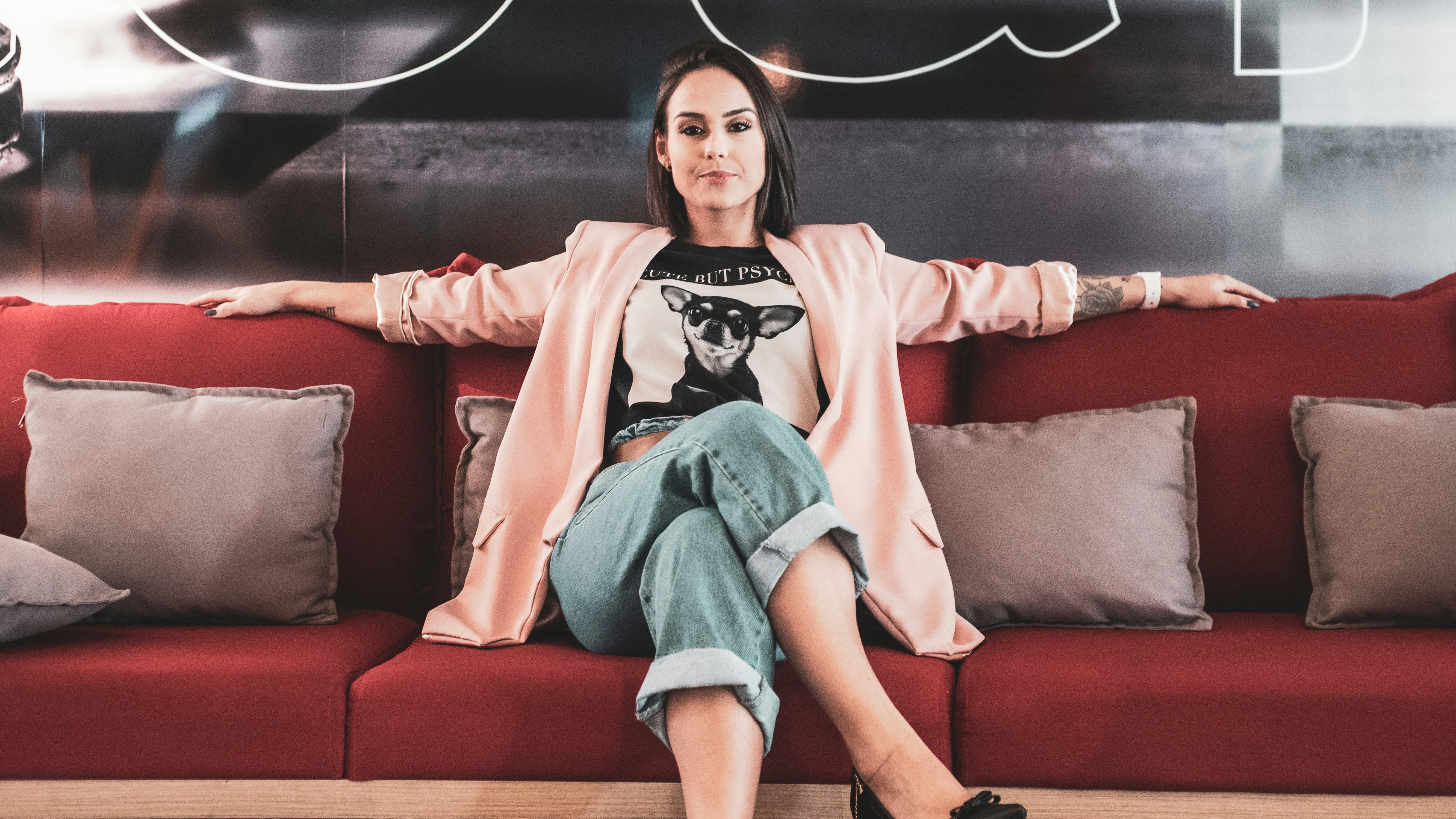 woman in black and white crew neck t-shirt sitting on red couch