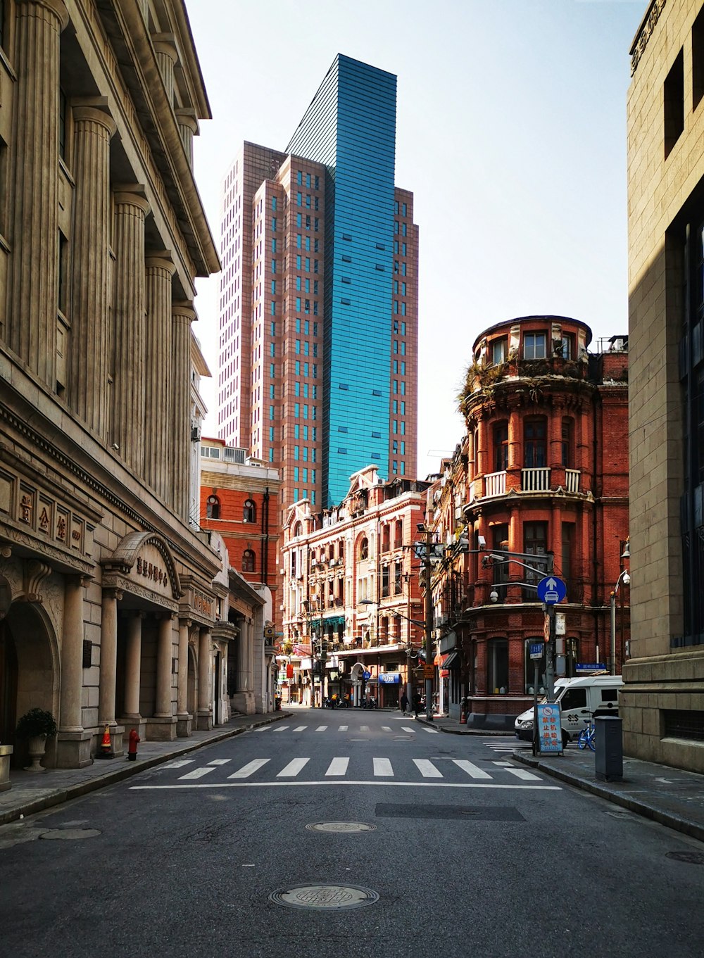 cars on road in between high rise buildings during daytime