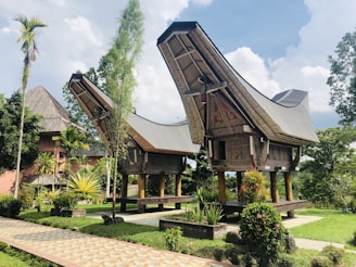 brown wooden house surrounded by green trees under blue sky during daytime