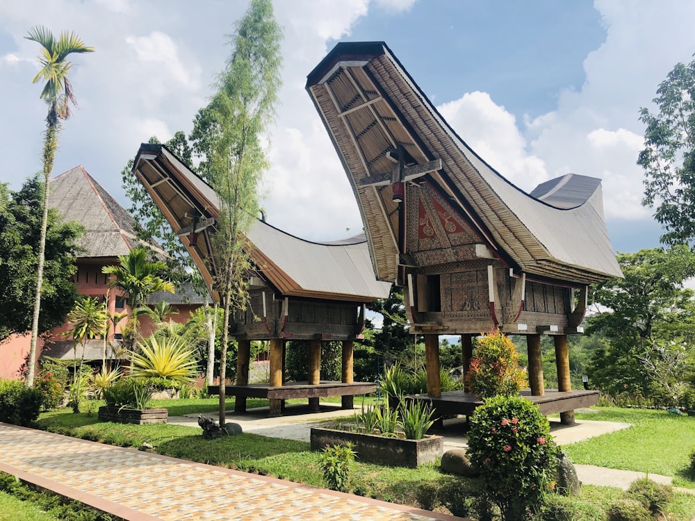 brown wooden house surrounded by green trees under blue sky during daytime