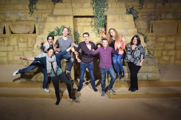 Excited travelers posing in front of exotic landscapes on a group adventure tour.