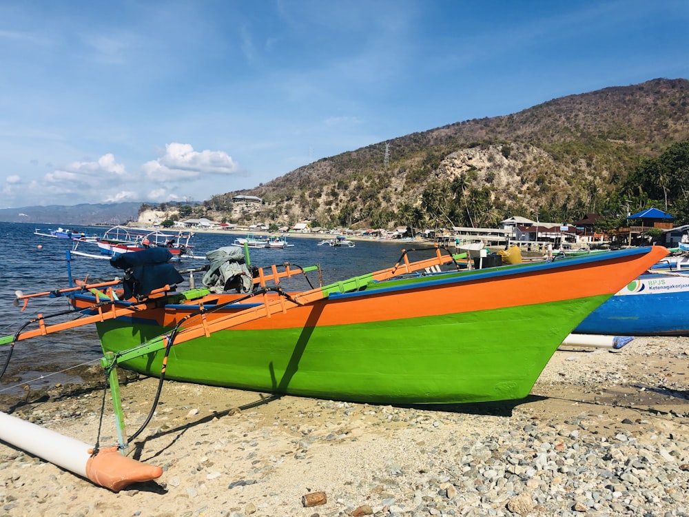 green and white boat on beach shore during daytime