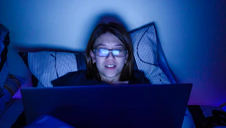 A student studying late at night using Neecet’s portal on a laptop under soft blue lighting.