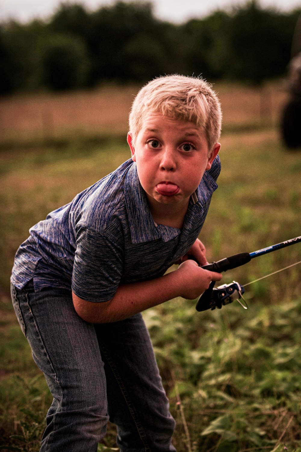 Boy in gray and black stripe polo shirt and blue denim jeans