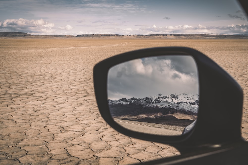 car side mirror with reflection of clouds on water
