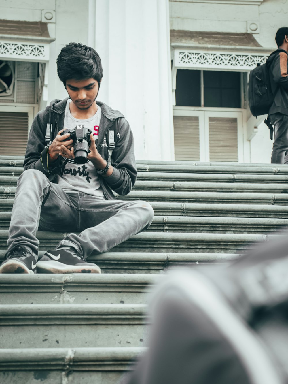 man in gray hoodie sitting on stairs