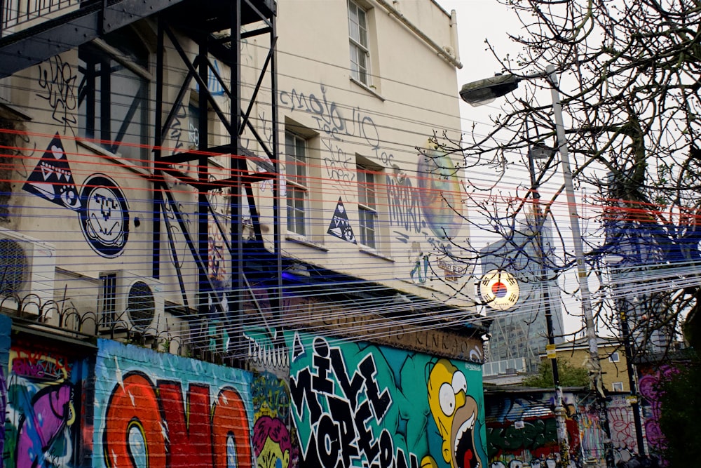 graffiti on wall near bare tree during daytime