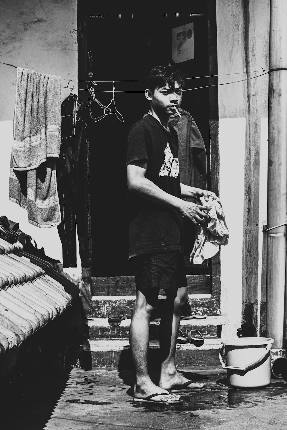 man in black polo shirt and black shorts standing beside wall