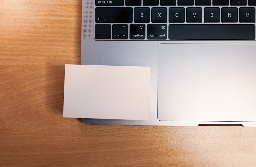 silver macbook on brown wooden table