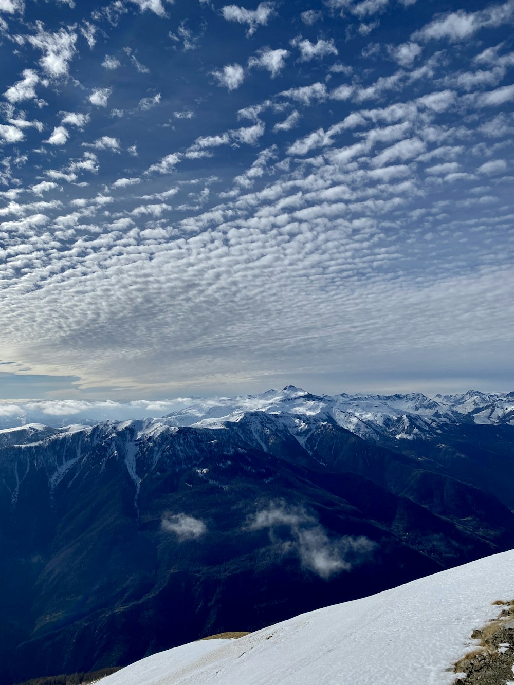 white clouds over snow covered mountains