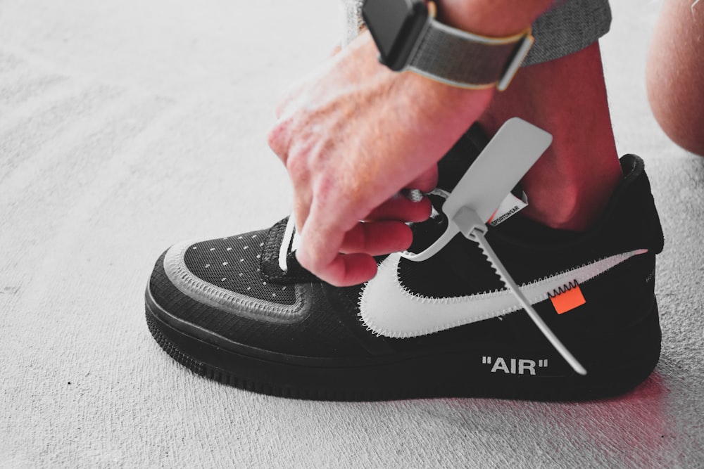 person wearing black and white nike air force 1 high