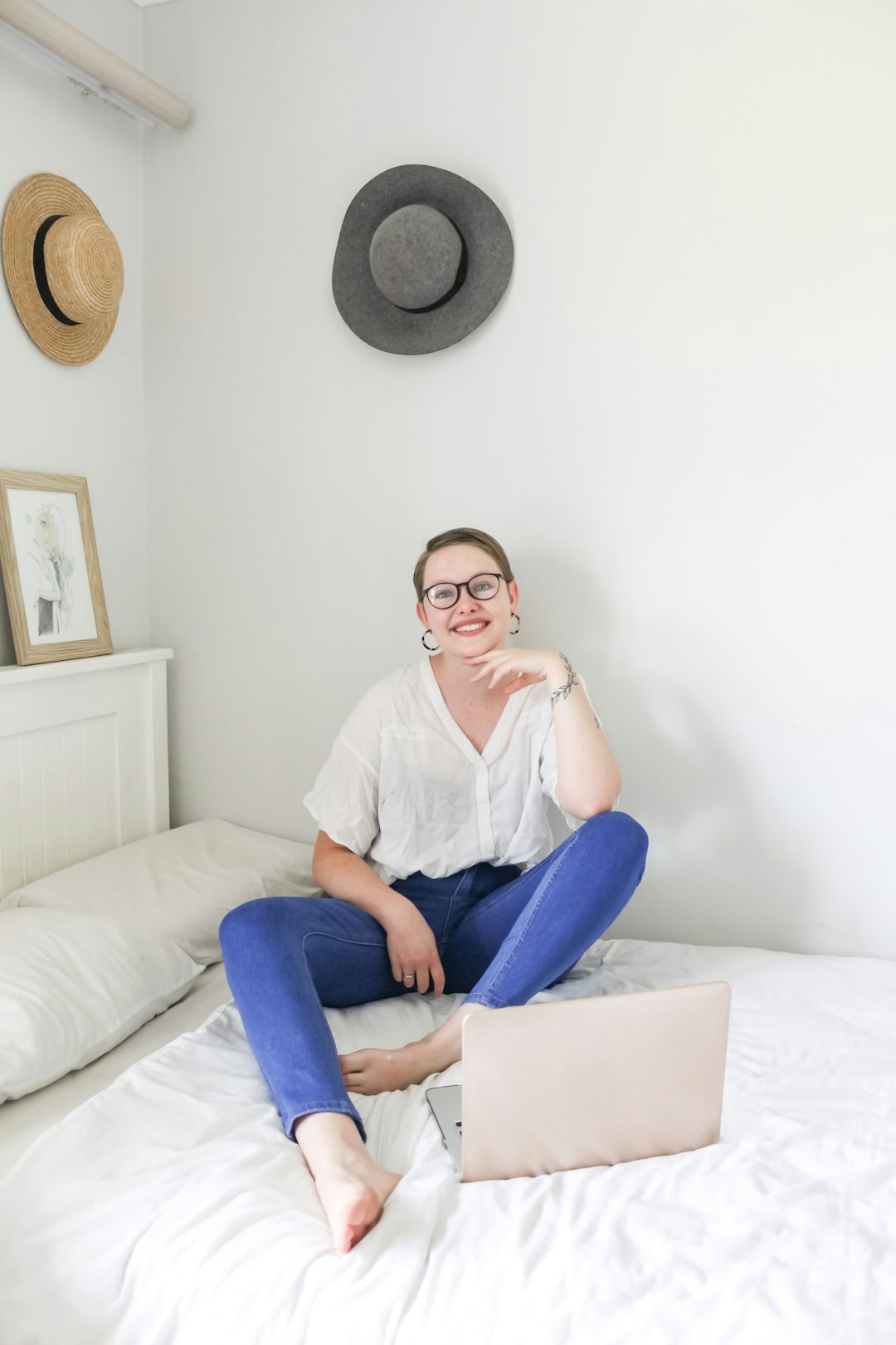 woman in white shirt and blue denim jeans sitting on white couch