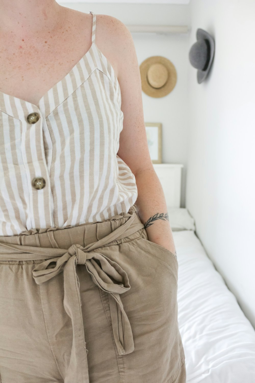 woman in white and gray stripe tank top and gray denim shorts