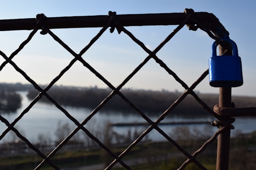 Close-up of sleek fencing panels with locks, set against a Dubai urban skyline.