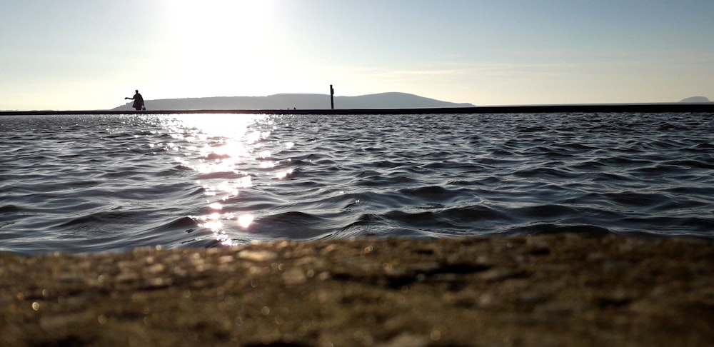 person standing on the seashore during daytime