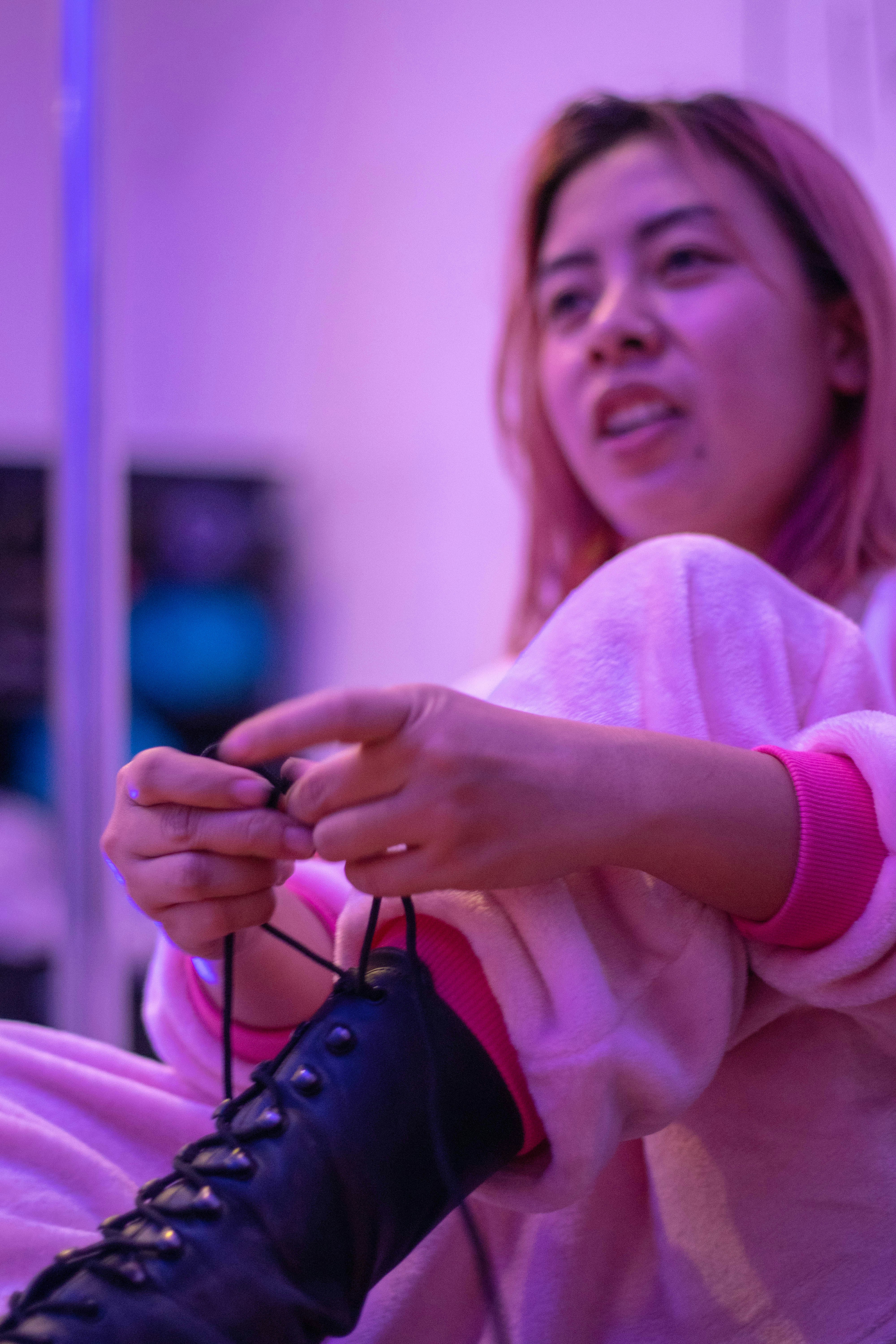 Mujer en suéter rosa sosteniendo bolso de cuero negro