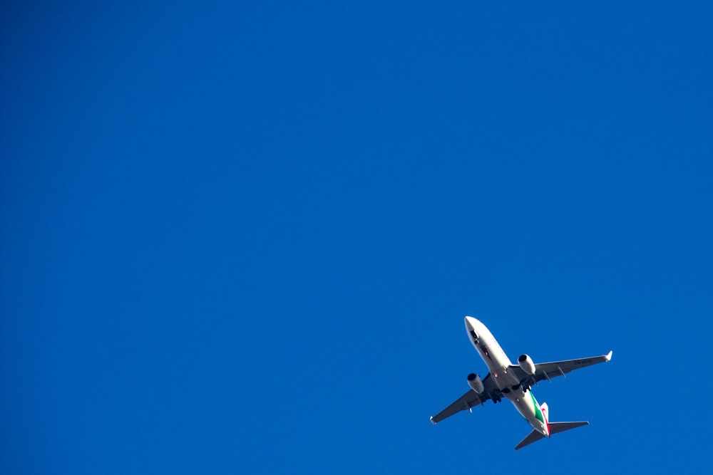 aeroplano bianco e nero a mezz'aria durante il giorno