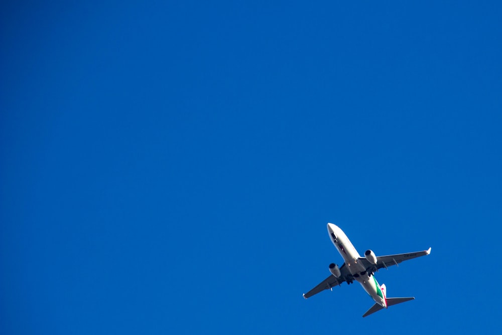 white and black airplane in mid air during daytime