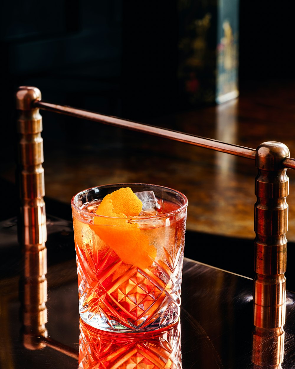 klares Trinkglas mit Orangensaft auf braunem Holztisch